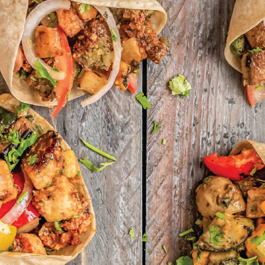Close-up of vibrant and flavorful tacos filled with grilled chicken, fresh vegetables, and garnished with cilantro, showcasing the rich culinary traditions of Texas.