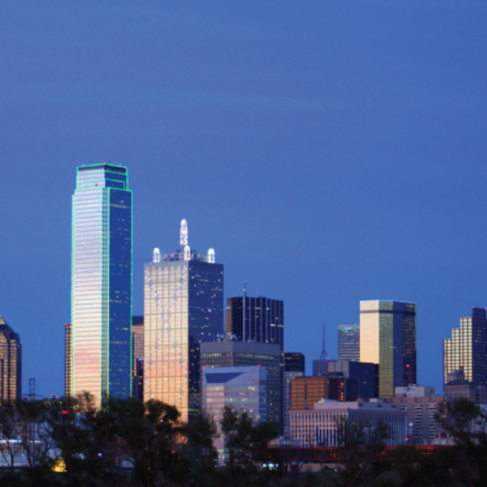 Dallas skyline at dusk featuring iconic structures like the Reunion Tower and reflective glass skyscrapers, illuminated against the evening sky.