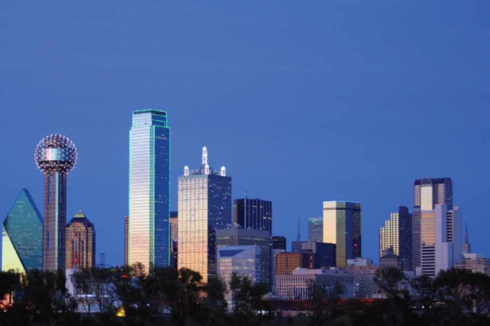 Dallas skyline at dusk featuring iconic structures like the Reunion Tower and reflective glass skyscrapers, illuminated against the evening sky.